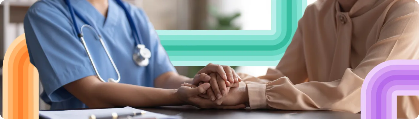A nurse holding a patient's hand, wrapped in the Joji ribbon motif