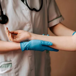 A nurse examining a patient's arm during a visit